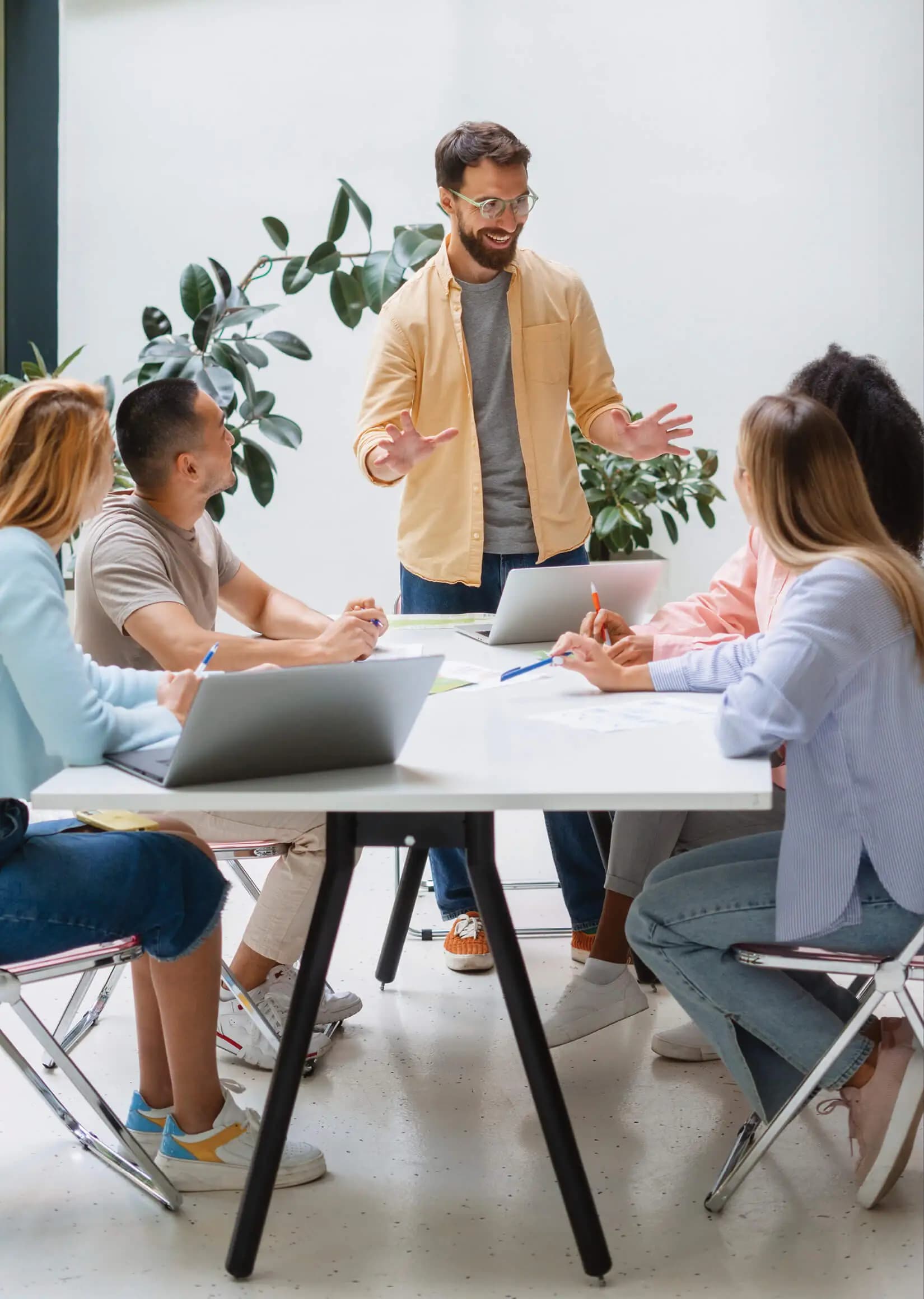 A manager presenting to a team seated around a conference table